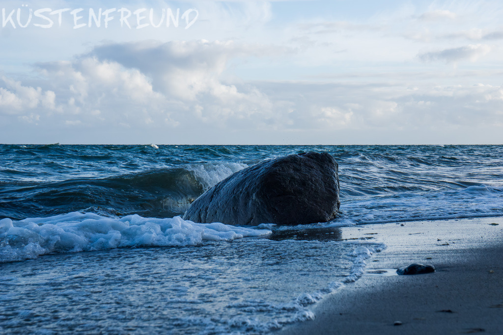 Findling am Spülsaum mit sanfter Welle // Ostseebild | Entdecke deine Lieblingslandschaft von der Küste – auf Ostsee Leinwand, Nordsee Leinwand, Alu Dibond oder Acrylglas, passend für jeden Geschmack und Raum.