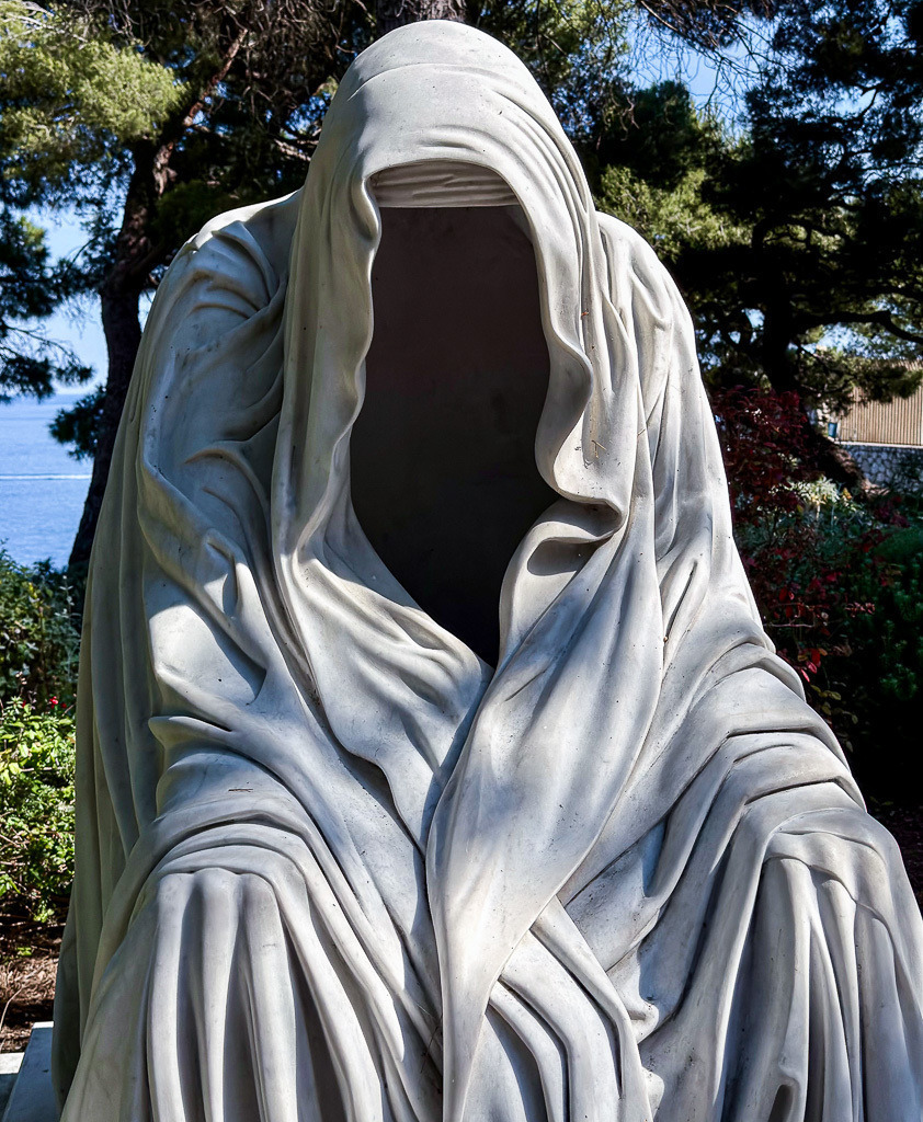The Silent Veil | A mysterious faceless sculpture photographed on the Palace Hill in Monaco. Wrapped in flowing stone-like folds, the silent figure creates a haunting atmosphere between mystery, elegance and surreal contemporary art. ✨ - Realisiert mit Pictrs.com