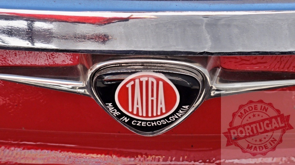 Tatra logo on a red vintage car made in Czechoslovakia | Close-up of the Tatra logo on the rear of a red vintage car, highlighting the craftsmanship and history of the Czechoslovakian automaker - Realized with Pictrs.com