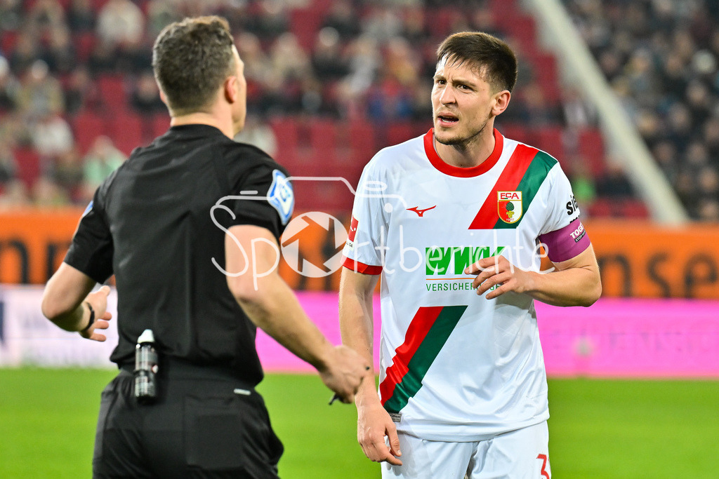 FC Augsburg - VfB Stuttgart | AUGSBURG, GERMANY - 22. MAERZ: Schiedrichter Felix ZWAYER erklärt Keven SCHLOTTERBECK (FC Augsburg 31) seine Entscheidung während dem Bundesligamatch zwischen dem FC Augsburg und dem VfB Stuttgart am 27. Spieltag in der WWK Arena / DFL REGULATIONS PROHIBIT ANY USE OF PHOTOGRAPHS AS IMAGE SEQUENCES AND/OR QUASI-VIDEO