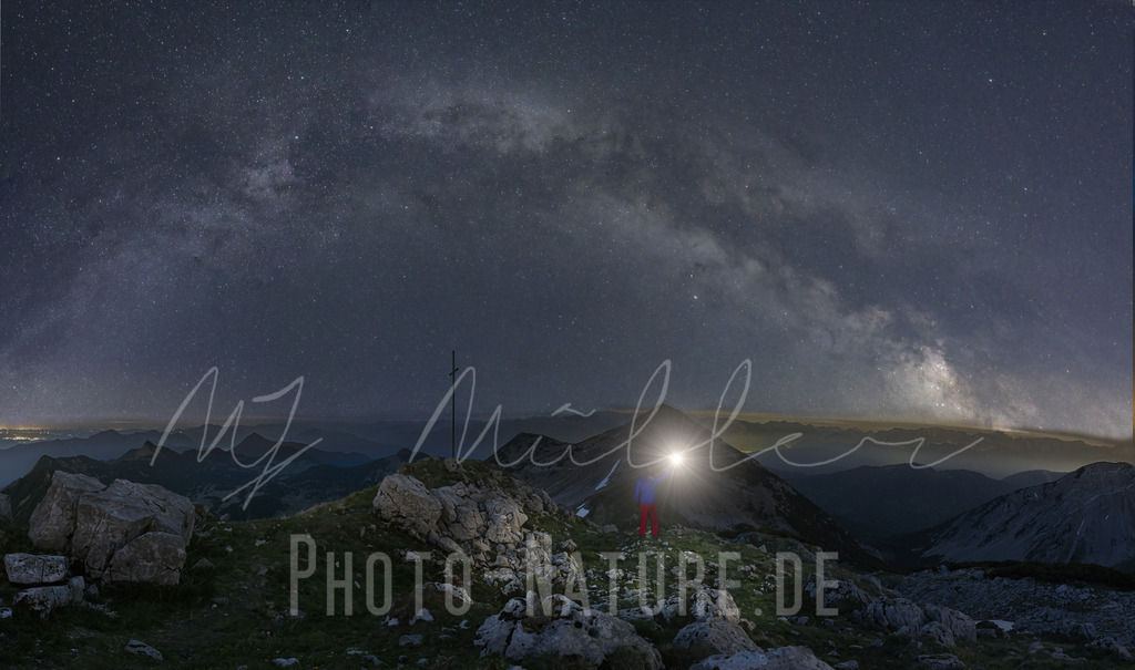 Ein Licht auf einem Berggipfel | Ein prächtiger Sternenhimmel über dem Gipfelkreuz - Realisiert mit Pictrs.com