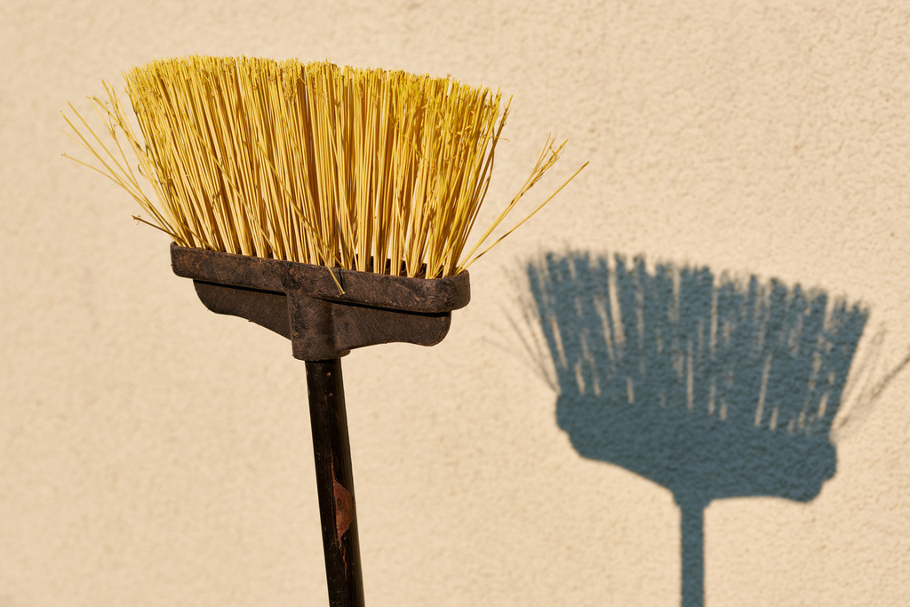 gelber Kehrbesen mit Schatten an der Wand | Austria - April 20, 2022: gelber Kehrbesen mit Schatten an der Wand. - Realisiert mit Pictrs.com