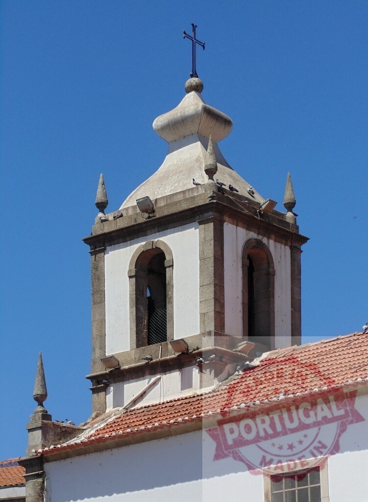 Portuguese church bell tower with cross under blue sky. Aveiro - Portugal | Bell tower of an old Portuguese church, featuring a cross, traditional roof tiles, and pigeons - Realized with Pictrs.com