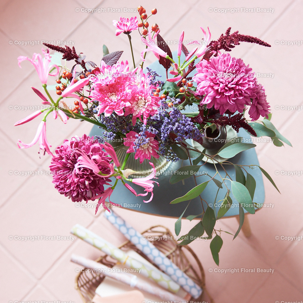 Rosa Strauß aus Dahlien und Chrysanthemen auf rosa Fliesen | Dahlien und Chrysanthemen in Glasvase von oben auf einem rosa gefließten Fußboden, im Quadrat - Realisiert mit Pictrs.com