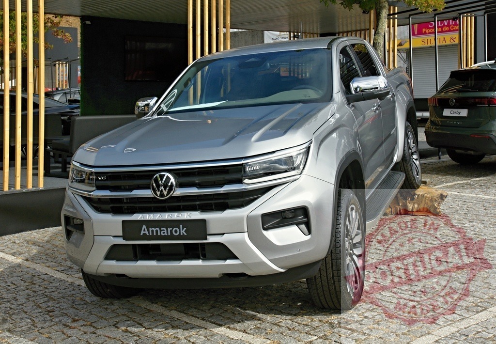 Volkswagen Amarok pickup truck on display elevating a wheel | Volkswagen Amarok pickup truck showcasing its capabilities on a cobblestone surface - Realized with Pictrs.com