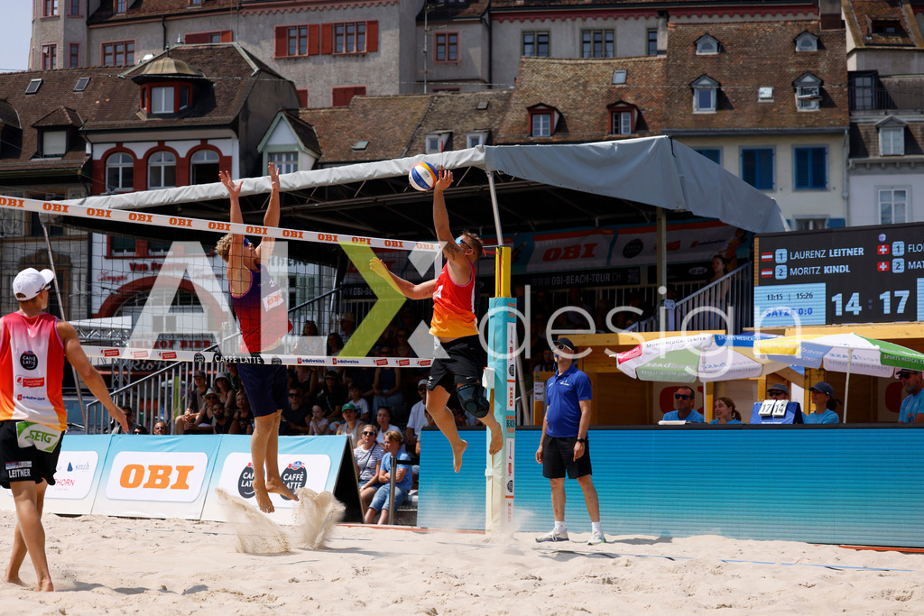 Obi BeachTour 2026 - Basel | BASEL, SWITZERLAND - JULY 19: MORITZ KINDL (AUT) attack / spike against MATHIS KÄLIN (SUI) block during the Obi BeachTour 2026 match between LEITNER / KINDL (AUT) and BREER / KÄLIN (SUI) at Barfüsserplatz on July 19, 2026 in Basel, Switzerland. - Realisiert mit Pictrs.com