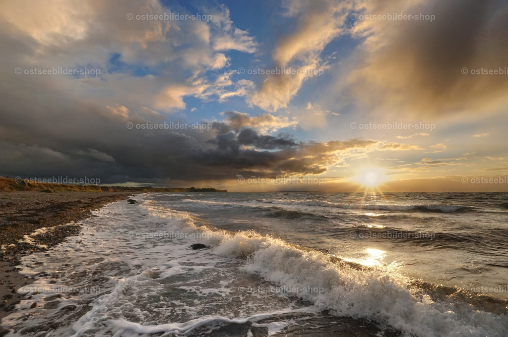 Goldener Oktoberabend an der Ostsee | Der Himmel bricht auf und die Abendsonne wirft ihr goldenes Licht über die Ostsee. Über der Küste zieht eine Regenfront am Horizont vorbei.