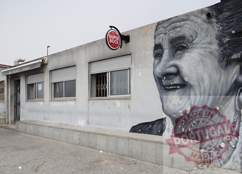 Super Bock sign on building with elderly woman mural | Urban street art mural depicting an elderly woman's happy portrait on a building wall - Realisiert mit Pictrs.com
