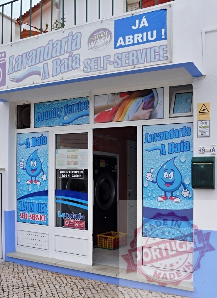 Lavandaria A Baía self-service laundry business storefront | Self-service laundry business Lavandaria A Baía with open sign on a building facade - Realized with Pictrs.com