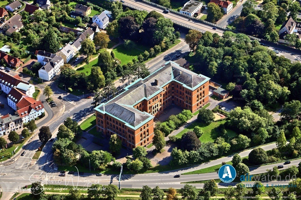 Luftbild Schleswig-Holsteinische Oberlandesgericht (OLG) in Schleswig | Es liegt unmittelbar gegenüber dem Schloss Gottorf in der Gottorfstraße 2 und wurde ursprünglich mit reichen Verzierungen und eindrucksvoller Größe gebaut, um mit dem Schloss konkurrieren zu können. Aufgrund seines wuchtigen Aussehens ist es im Volksmund als „Roter Elefant“ bekannt.