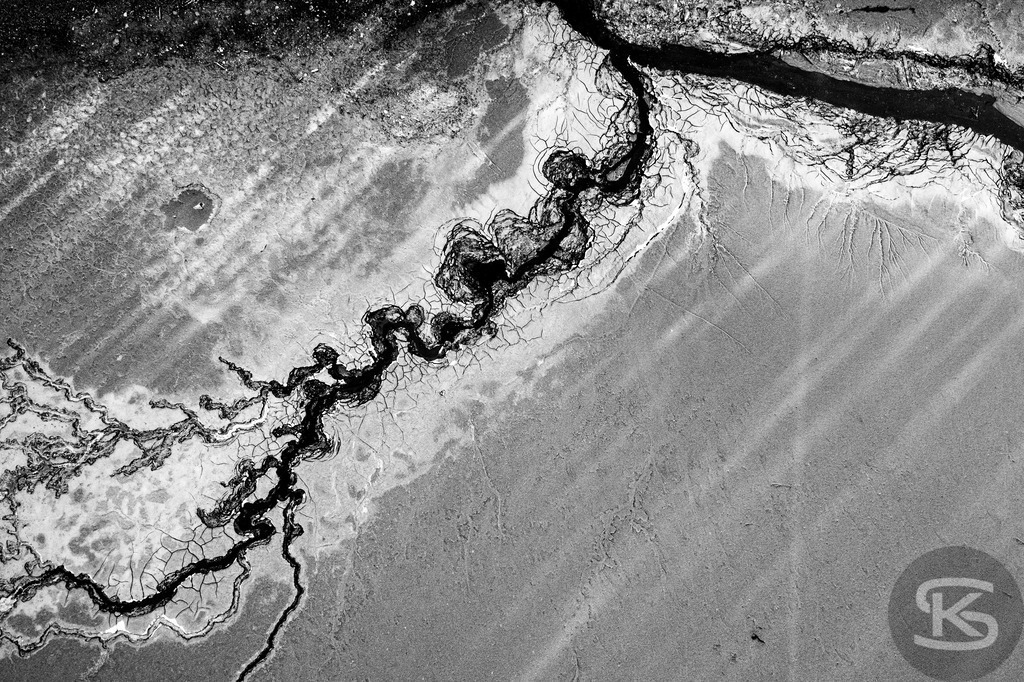 Ground Levels – Abstrakte Landschaften entwässerter Seen aus der Vogelperspektive | Ground Levels zeigt Drohnenaufnahmen entwässerter Seegründe, die zwischen Realität und Abstraktion oszillieren. Rinnsale, Pfützen und Muster verwandeln sich aus der Luft zu abstrakten Kompositionen – Fotokunst von Stefan Kuhn. - Realisiert mit Pictrs.com