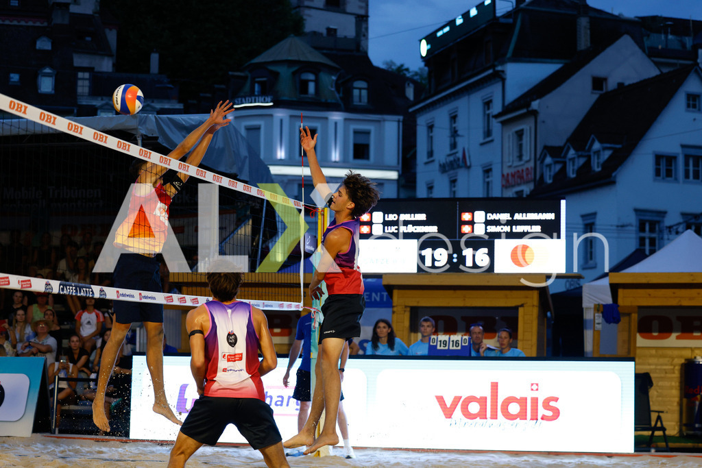 Obi BeachTour 2026 - Basel | BASEL, SWITZERLAND - JULY 17: LUC EMANUEL FLÜCKIGER (SUI) attack / spike against SIMON LEFFLER (SUI) block during the Obi BeachTour 2026 match between DILLIER / FLÜCKIGER (SUI) and ALLEMANN / LEFFLER (SUI) at Barfüsserplatz on July 17, 2026 in Basel, Switzerland. - Realisiert mit Pictrs.com