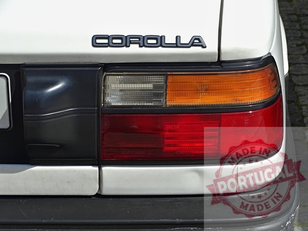 Toyota Corolla rear view with taillight and emblem | Toyota Corolla showing rear taillight, bumper, and car emblem on white body - Realized with Pictrs.com