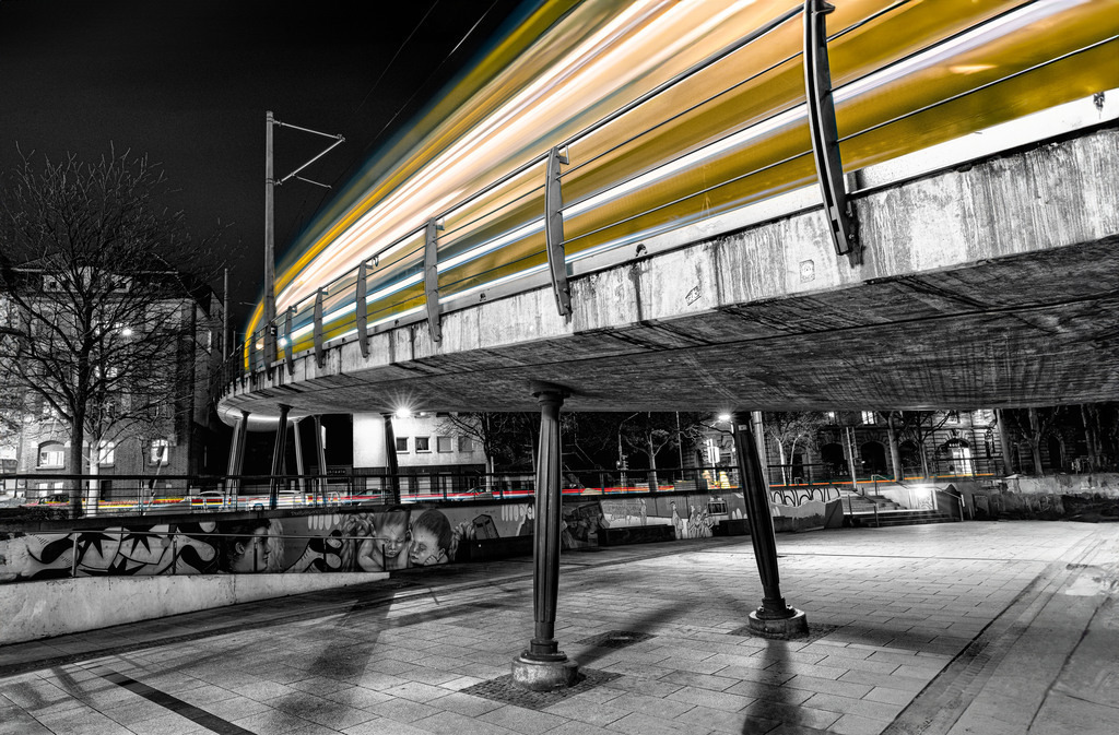 Die bekannte Zahnradbahn am Stuttgarter Marienplatz als Lichtschweif , in Schwarz-Weiß und Gelb | Das Bild zeigt die berühmte Stuttgarter Zahnradbahn (die „Zacke“) am Marienplatz in einer schwarz-weißen Langzeitbelichtung mit einem leuchtend gelben Lichtschweif. - Realisiert mit Pictrs.com