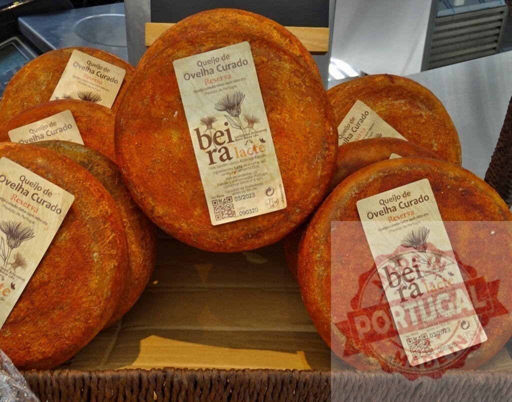 Portuguese Queijo de Ovelha Curado BeiraLacte sheep cheeses | Round Queijo de Ovelha Curado Reserva sheep cheeses for sale at a market - Realized with Pictrs.com