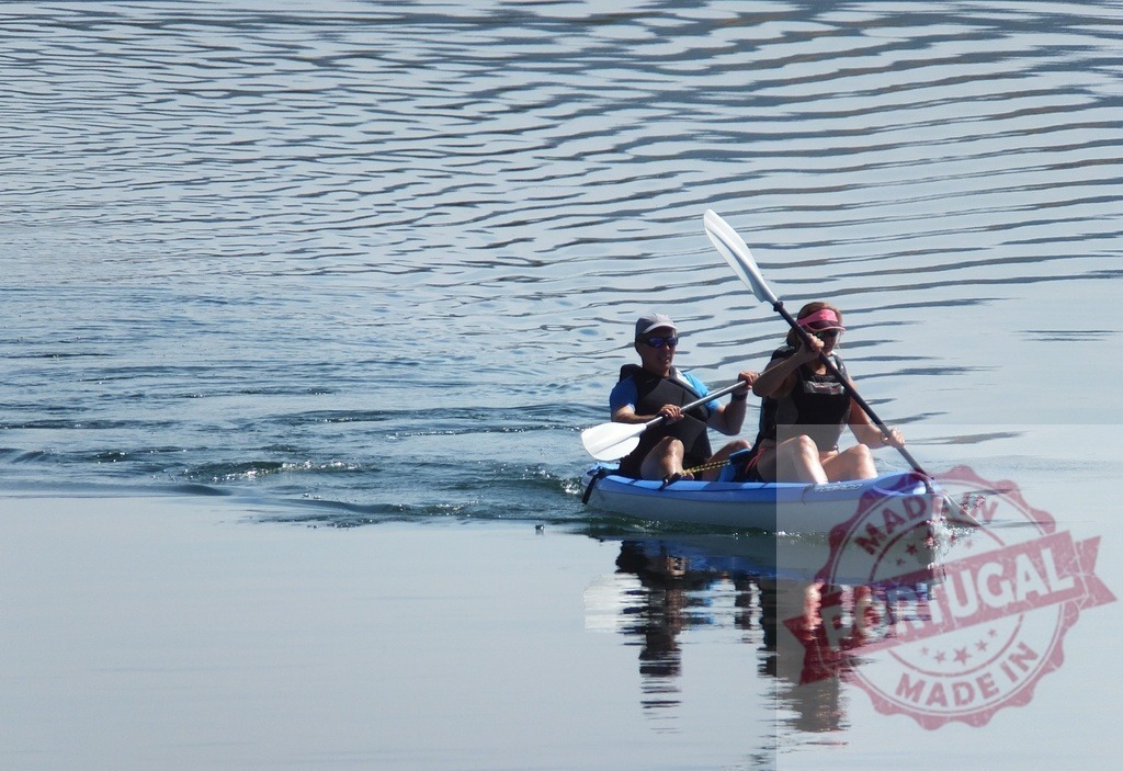 Two people kayaking shallow clear lake water | Two people enjoying a leisure outdoor activity, kayaking on a calm lake - Realized with Pictrs.com