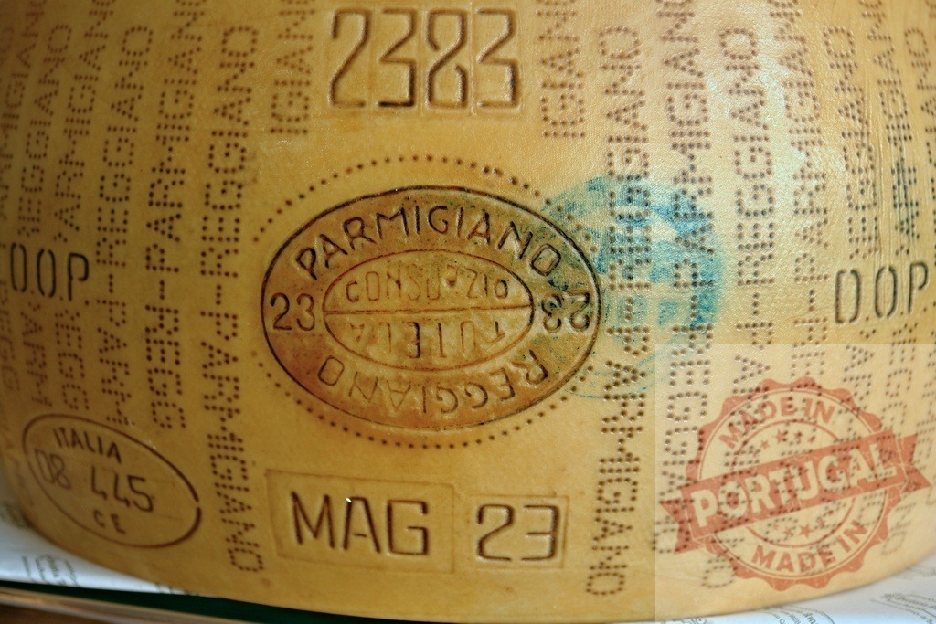 Parmigiano Reggiano cheese wheel rind with DOP stamps | Parmigiano Reggiano DOP cheese wheel rind showing authentication stamps and text - Realisiert mit Pictrs.com