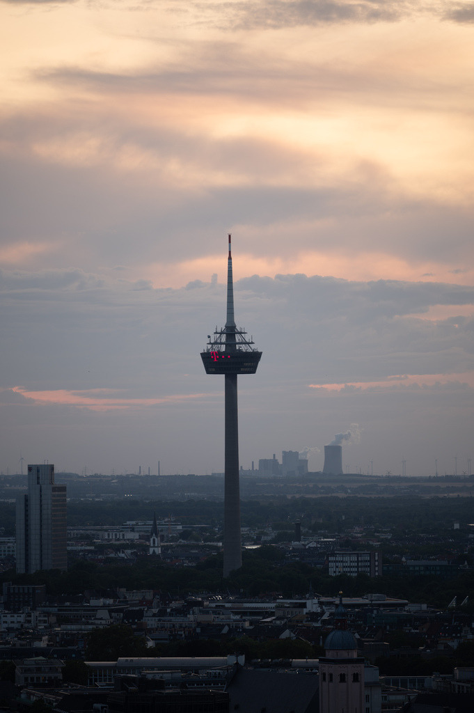 Colonius über Köln im Abendlicht | Der Kölner Fernsehturm Colonius erhebt sich über der Stadt unter einem sanft gefärbten Abendhimmel. Die reduzierte Komposition hebt die markante Silhouette des Turms hervor. - Realisiert mit Pictrs.com