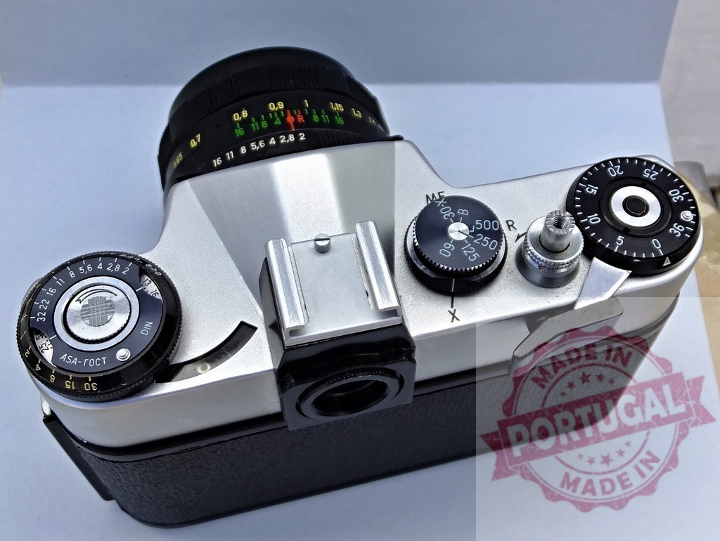 Zenit 35mm film camera analog photography hobby | Vintage Zenit SLR film camera with lens, dials, and controls on a clean background - Realized with Pictrs.com