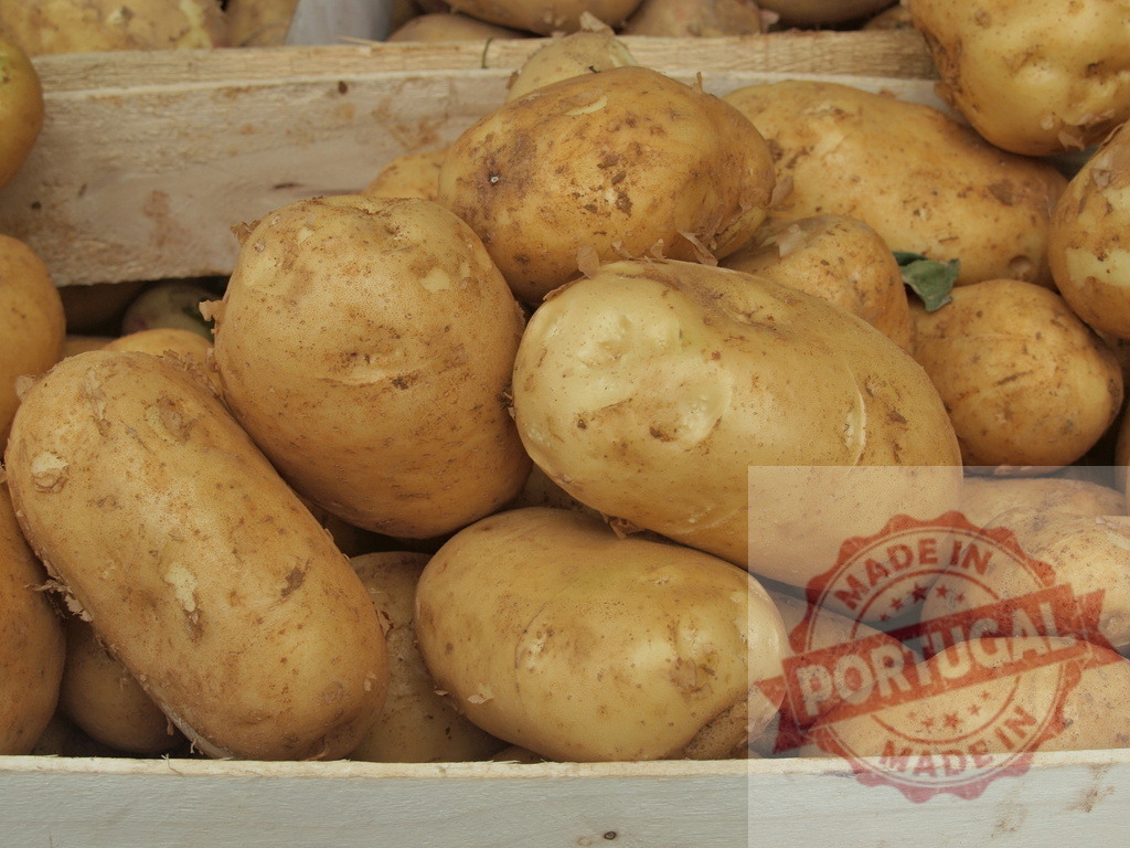 Fresh organic potatoes piled in wooden crates | Freshly harvested potatoes are filling a rustic wooden crate at a market stall - Realized with Pictrs.com