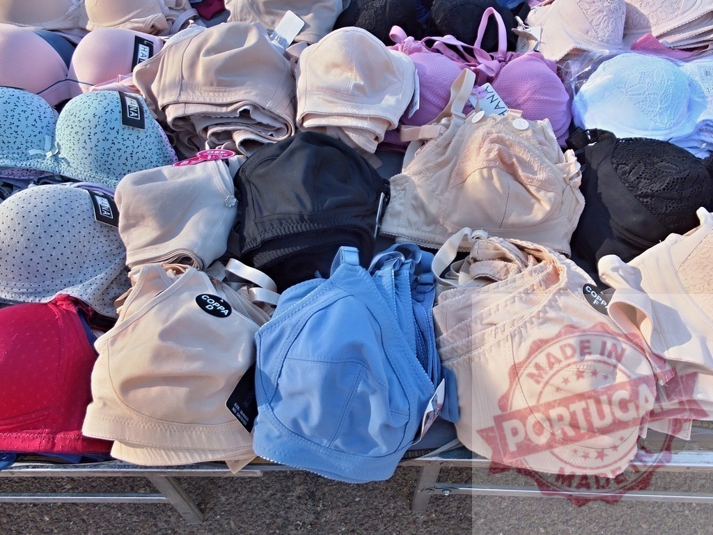 Various bras for sale at street market stall | Many colorful bras are piled up on a market stall display for selling - Realisiert mit Pictrs.com