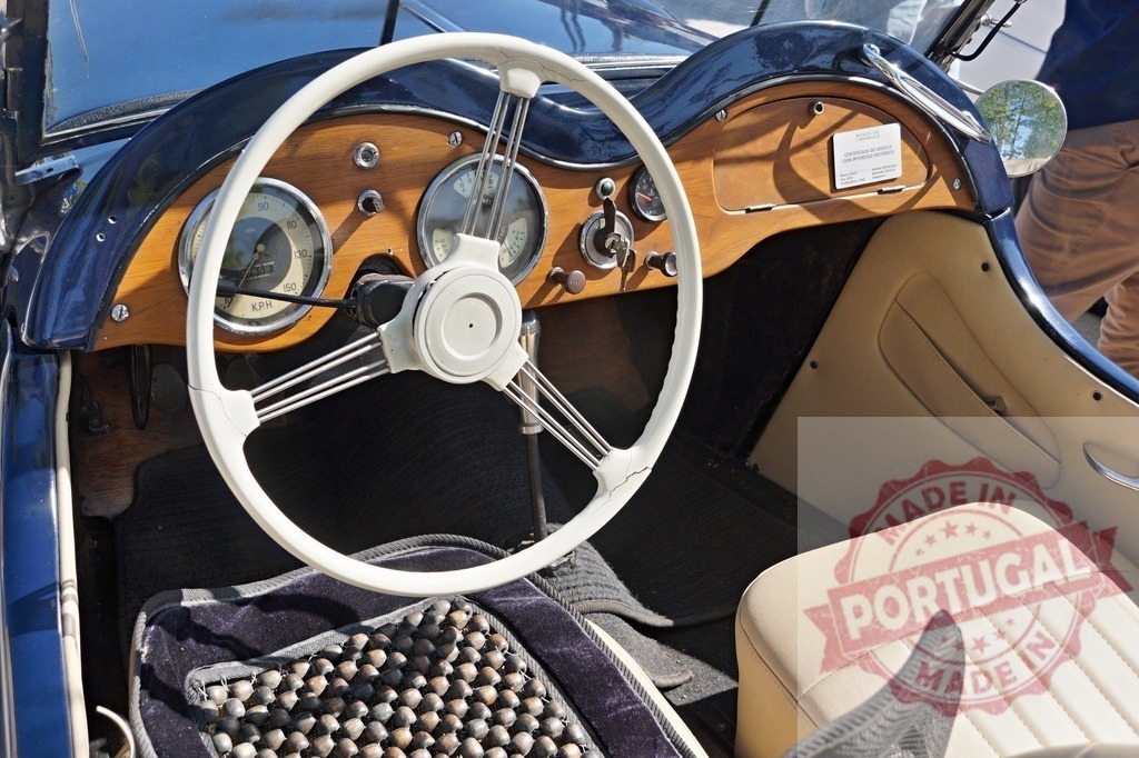 Vintage classic car dashboard and steering wheel interior | Vintage classic car interior showing dashboard, white steering wheel, and wooden details - Realized with Pictrs.com