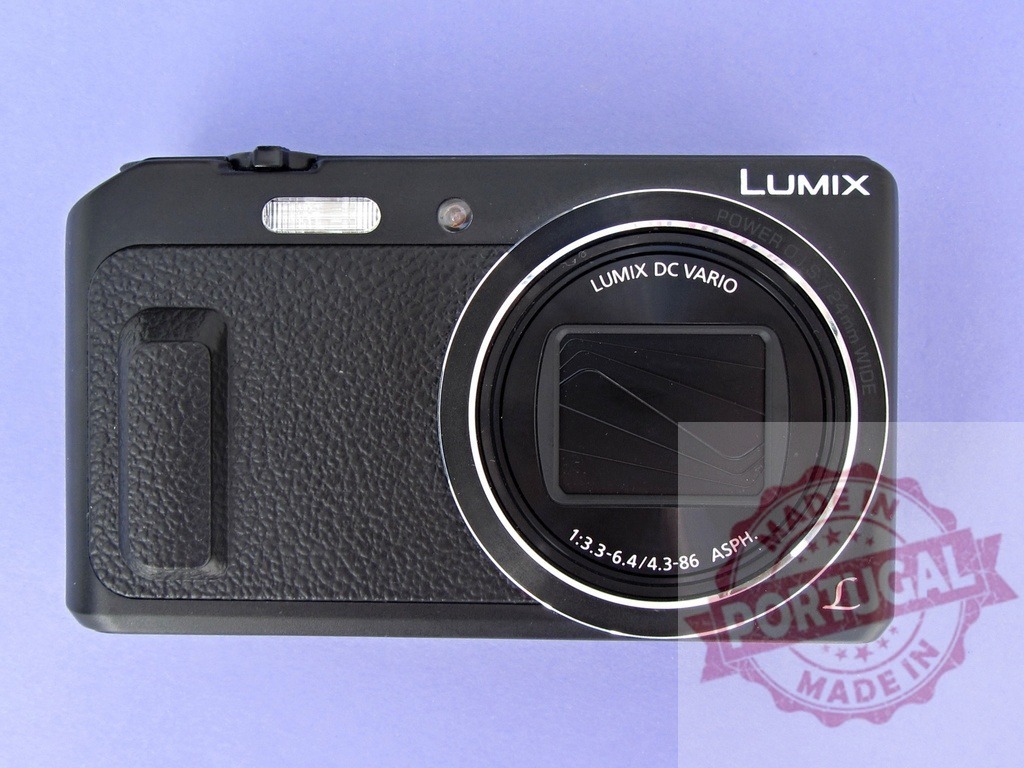 Panasonic Lumix digital camera lying on lavender surface | Black compact point and shoot camera with lens and flash on a purple background - Realized with Pictrs.com