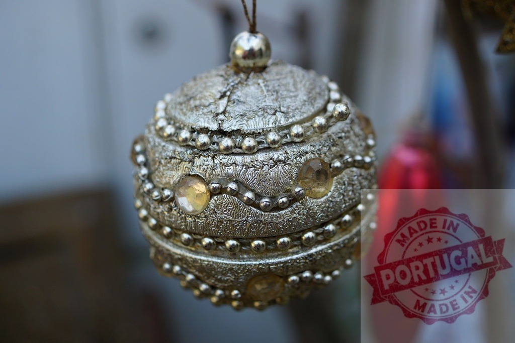 Silver christmas ball hanging and shining with blurred background | Silver christmas ball with yellow decorations hanging with a blurred background - Realized with Pictrs.com