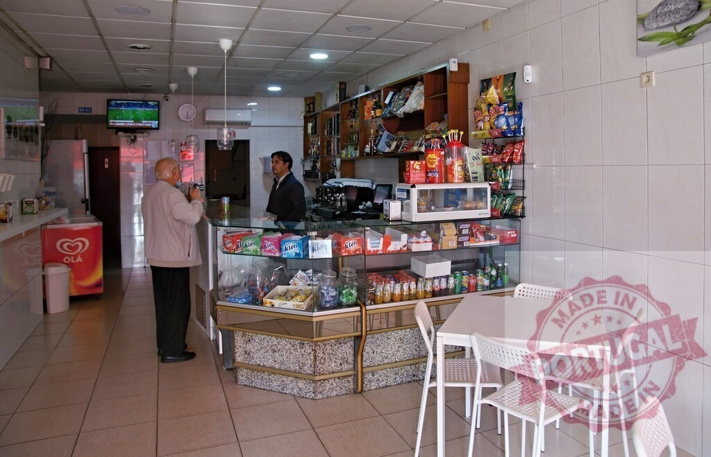 Customer receiving service at local snack bar | Customer interacting with cashier at an inside snack bar with various products - Realized with Pictrs.com