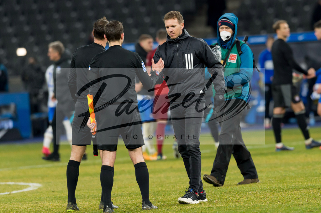 BSCFCB20220123_139 | Fussball, Herren: Trainer Julian Nagelsmann (FC Bayern Muenchen) und Schiedsrichter Bastian Dankert klatschen sich ab bei dem Spiel der 1. Bundesliga zwischen Hertha BSC und FC Bayern Muenchen im Olypiastadion am 23.01.2022 in Berlin, Deutschland.DFB / DFL REGULATIONS PROHIBIT ANY USE OF PHOTOGRAPHS AS IMAGE SEQUENCES AND/OR QUASI-VIDEO. - Realisiert mit Pictrs.com