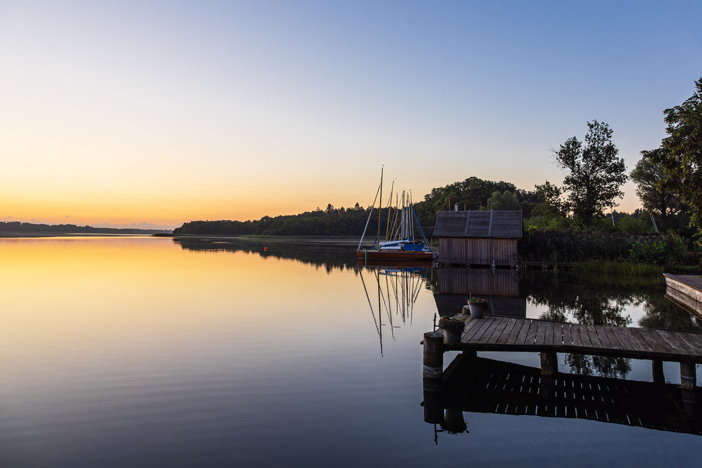 Steg, Bootshaus und Segelboote in Seedorf am Schaalsee im Sonnenaufgang | Steg, Bootshaus und Segelboote in Seedorf am Schaalsee im Sonnenaufgang.