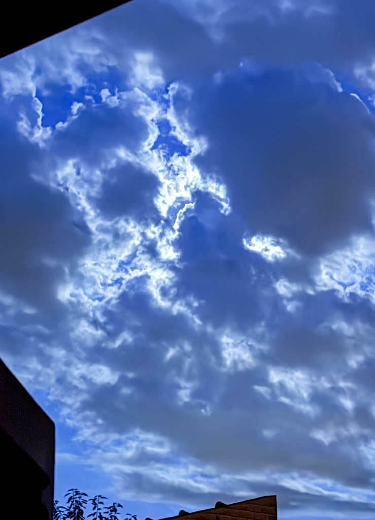 Nachtakzente – Silberstreif I | Dramatische Fotokunst im Großformat. Diese beeindruckende Aufnahme fängt das magische Leuchten des Mondlichts hinter einer dichten Wolkendecke ein. Das intensive Zusammenspiel aus tiefem Nachtblau, strahlenden Silberkanten und der minimalistischen Silhouette urbaner Architektur im Vordergrund macht diesen Fine Art Print zu einem exklusiven Statement für moderne Wohnräume, Lofts oder Büros. - Realisiert mit Pictrs.com