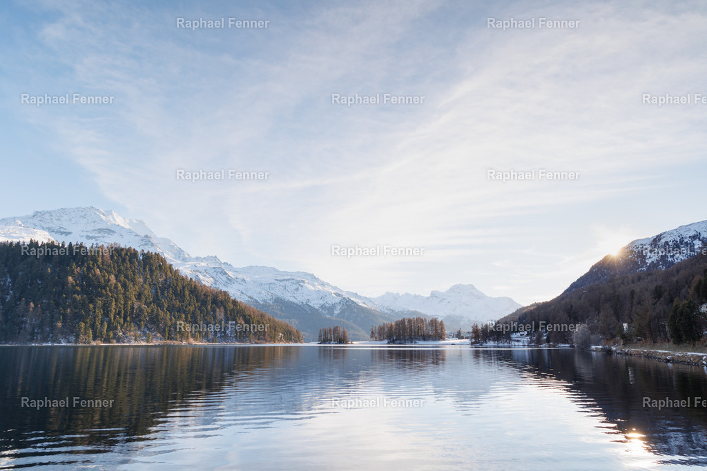 Winterblick über den Lej da Champfèr | Ein klarer Wintermorgen am Lej da Champfèr – aufgenommen mit Blickrichtung Silvaplana. Das ruhige Wasser spiegelt die verschneiten Berghänge, während das sanfte Licht der Wintersonne den Himmel aufhellt. Diese Aufnahme zeigt das Engadin in seiner stillsten und zugleich eindrucksvollsten Form. Ideal als hochwertiger Fine Art Print für alpine Wohnträume.