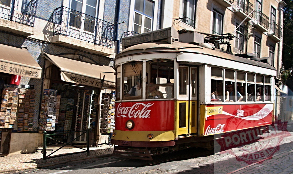 Vintage Lisbon Tram passing souvenir shop in Alfama district | Yellow and red vintage tram passing a souvenir shop in Lisbon's Alfama district - Realisiert mit Pictrs.com
