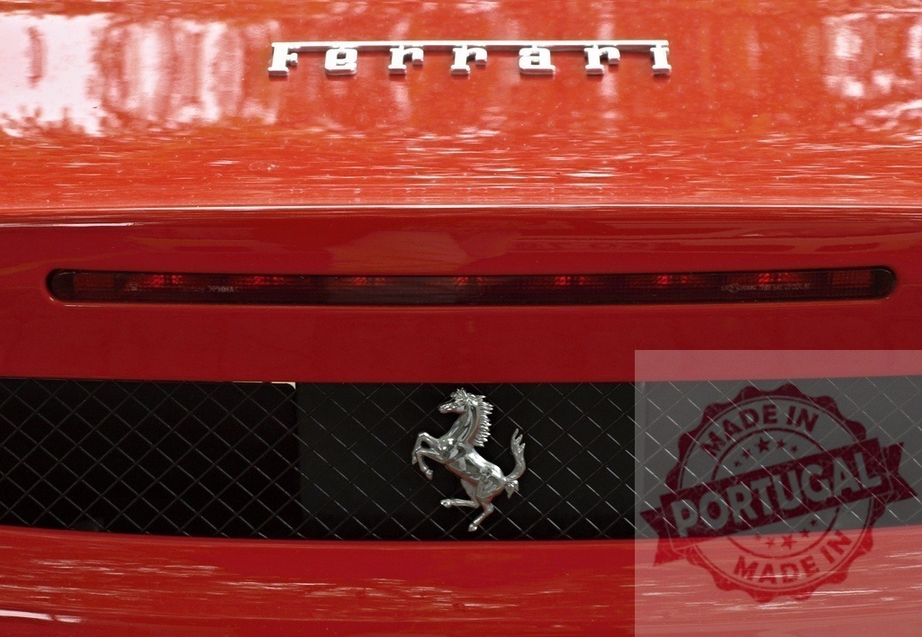Ferrari prancing horse emblem on red sports car | Ferrari logo and iconic prancing horse on a red luxury sports car - Realisiert mit Pictrs.com