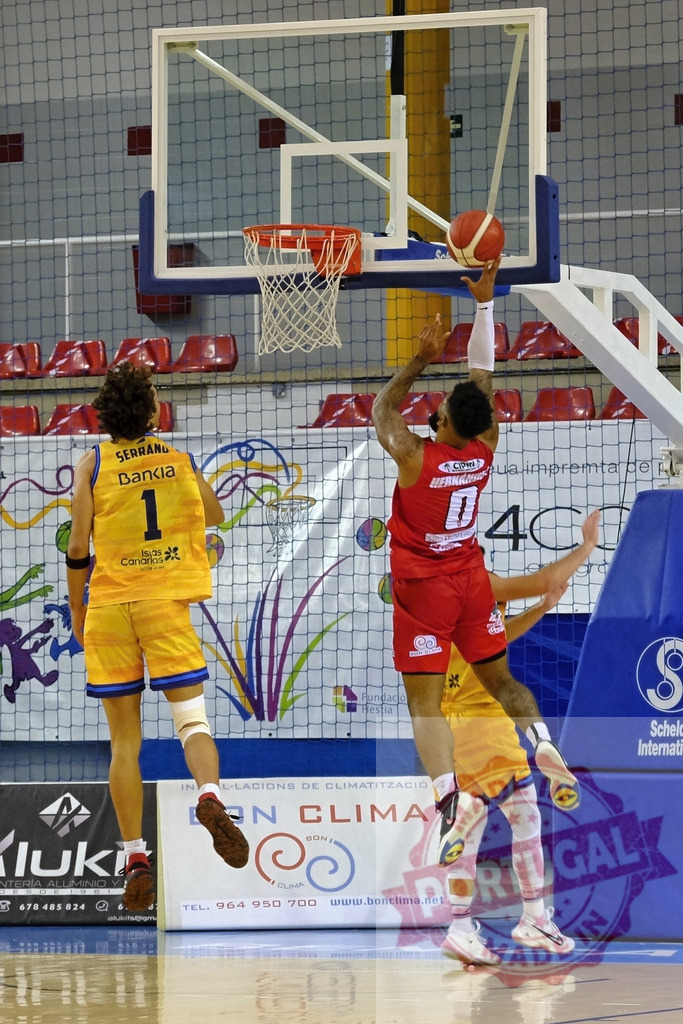 Basketball player scoring a layup during a competitive game | Player in red jersey jumping to score a basketball layup shot during a game - Realisiert mit Pictrs.com