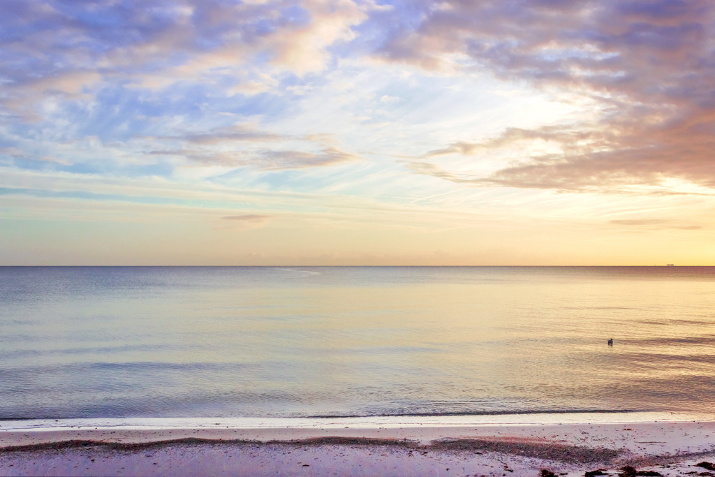 Wandbild: Morgenrot an der Eckernförder Bucht | Dieses Wandbild im Querformat zeigt eine schöne morgendliche Lichtstimmung an der Eckernförder Bucht. Der Horizont leuchtet in schönen warmen Farben, die sich auch im Meer spiegeln. Im Vordergrund befindet sich der Sandstrand - Realisiert mit Pictrs.com