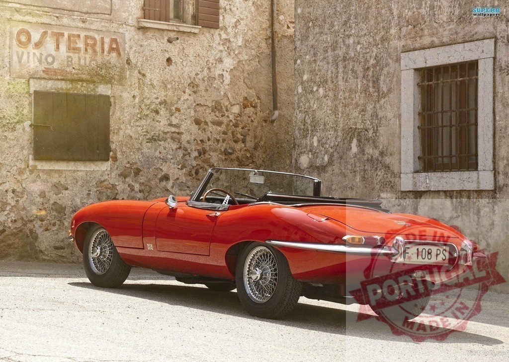 Red Jaguar E-Type parked by Italian osteria wall | Red Jaguar E-Type convertible parked in front of rustic stone building in Italy - Realisiert mit Pictrs.com