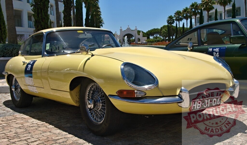 Classic yellow Jaguar E-Type parked in luxury resort | Shiny vintage Jaguar E-Type parked on cobblestone street in front of a luxury resort - Realized with Pictrs.com