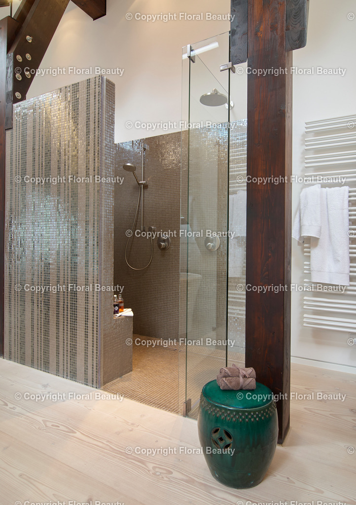 Braungeflieste Bisazza-Dusche in Luxusbadezimmer. | Dusche mit braunen Bisazza-Fliesen und Handtuchtrockner. Holzträger und Dielenboden. - Realisiert mit Pictrs.com