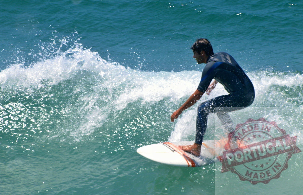 Surfer riding a wave in the ocean wearing a wetsuit | Surfer riding a wave in the ocean wearing a wetsuit during a sunny summer day - Realized with Pictrs.com