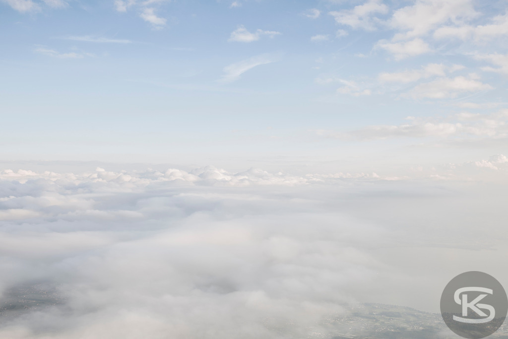 Luftaufnahme einer Ballonfahrt: Sanfte Wolkendecke & Blauer Himmel – Naturfoto | Hochauflösende Luftaufnahme einer dichten, weißen Wolkendecke, die eine heitere und verträumte Atmosphäre schafft. Perfektes Natur- und Reisebild. Ballonfahrt - Realisiert mit Pictrs.com