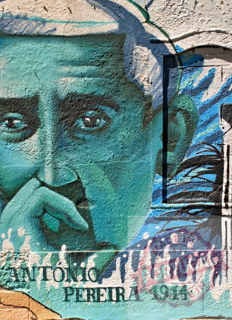 Antonio pereira mural painting representing thinking man with hand on chin | Close-up of colorful mural depicting Antonio Pereira, a thinking man with his hand on his chin, created with spray paint on a textured wall - Realisiert mit Pictrs.com
