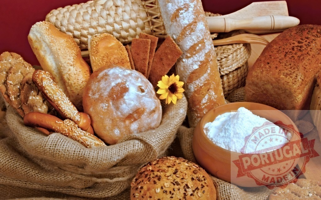 Assortment of fresh baked bread products and flour | Various types of bread and bakery items arranged on burlap with a bowl of white flour - Realisiert mit Pictrs.com