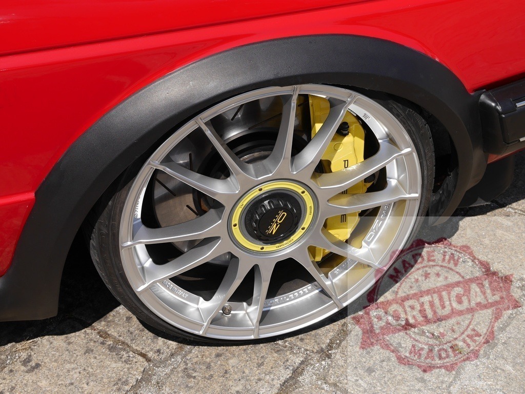 Red tuning car showing OZ Racing wheel yellow brake caliper | Red car with silver OZ Racing wheel, yellow brake caliper, and performance tire - Realized with Pictrs.com