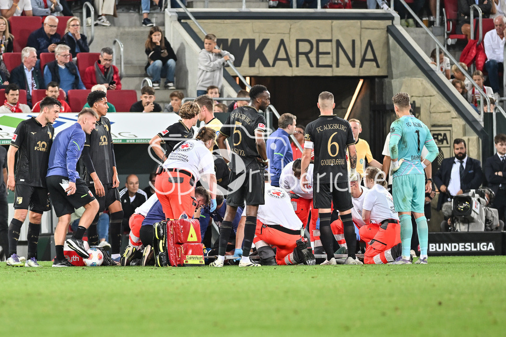 FC Augsburg - FC Bayern München | Nach einem Zusammenprall mit Sascha BOEY (FC Bayern Muenchen 23) muss der Verletzte Robin FELLHAUER (FC Augsburg 19) von den Sanitätern auf einer Trage vom Platz getragen werden / Bundesliga: FC Augsburg - FC Bayern München; WWK-Arena am 30.08.2025 / DFL REGULATIONS PROHIBIT ANY USE OF PHOTOGRAPHS AS IMAGE SEQUENCES AND/OR QUASI-VIDEO