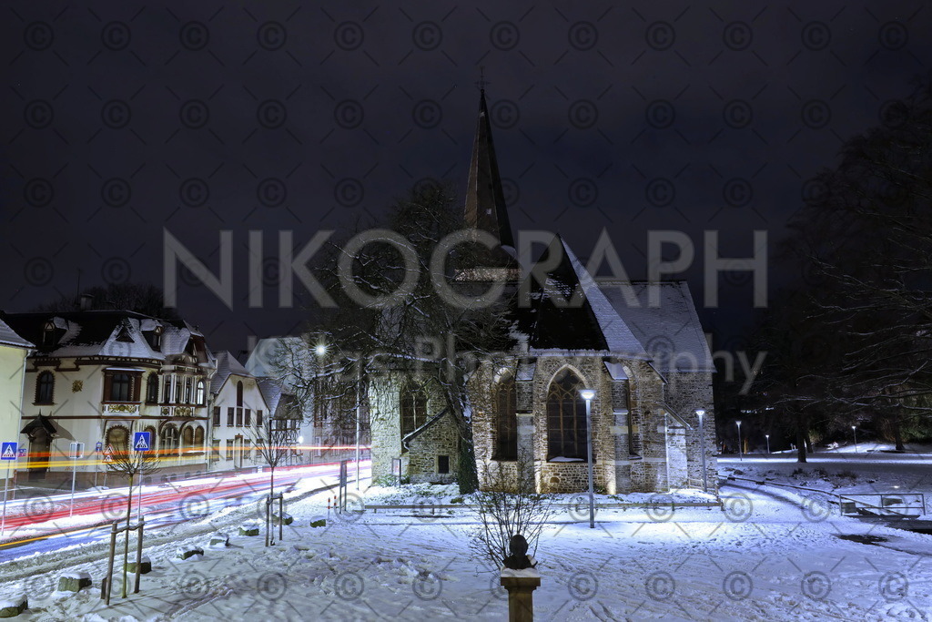 Die Iserlohner Bauernkirche im Schnee | Die Ostseite der evangelischen Kirche St. Pankratius (Bauernkirche) vor der winterlichen Fassade der Iserlohner Altstadt. Der schneebedeckte Fritz-Kühn-Platz kontrastiert zum Nachthimmel. Die evangelische Kirche St. Pankratius in Iserlohn gilt als eines der ältesten Bauwerke der Stadt. Man schätzt, dass die Kirche rund um das Jahr 985 erbaut wurde. Die Kirche wird im Volksmund auch Bauernkirche genannt. Das Bild eignet sich als Wandbild oder als Kalenderbild. Stellen Sie sich doch einfach einen individuellen Kalender aus verschiedenen Bildmotiven zusammen.