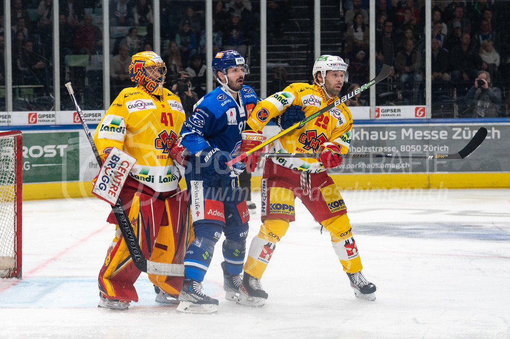 Playoffs: ZSC Lions - EHC Biel-Bienne | 27.03.2022, Zürich, Hallenstadion, Playoffs: ZSC Lions - EHC Biel-Bienne, #91 Denis Hollenstein (ZSC) im Sandwich von #41 Torhüter Elien Paupe (Biel) und #29 Beat Forster (Biel). - Realisiert mit Pictrs.com