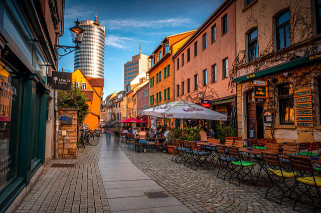 2024-04-06_18-17-35_500 | Die Restaurant Straße Wagnergasse mit dem Jentower im Hintergrund bei Sonnenuntergang und blauem Himmel, Jena, Thüringen, Deutschland - Realisiert mit Pictrs.com