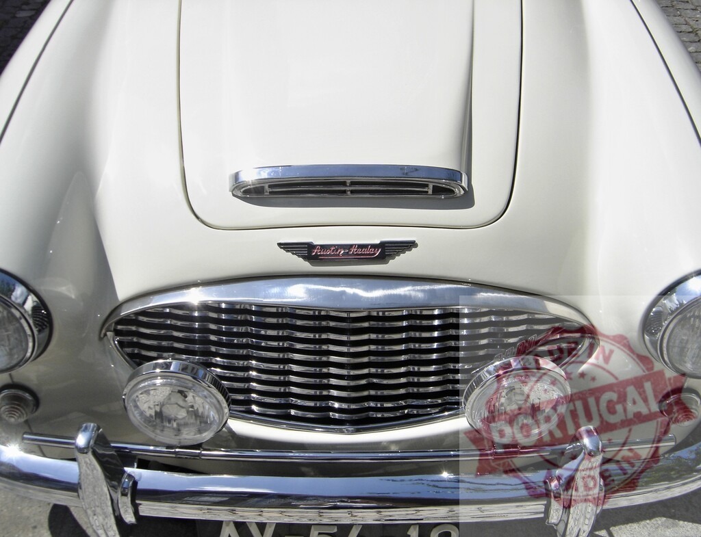 White Austin-Healey Sprite Frogeye Showing its Iconic Face and Grille | Close-up of a white Austin-Healey Sprite, highlighting the distinctive frogeye headlights and classic grille - Realisiert mit Pictrs.com